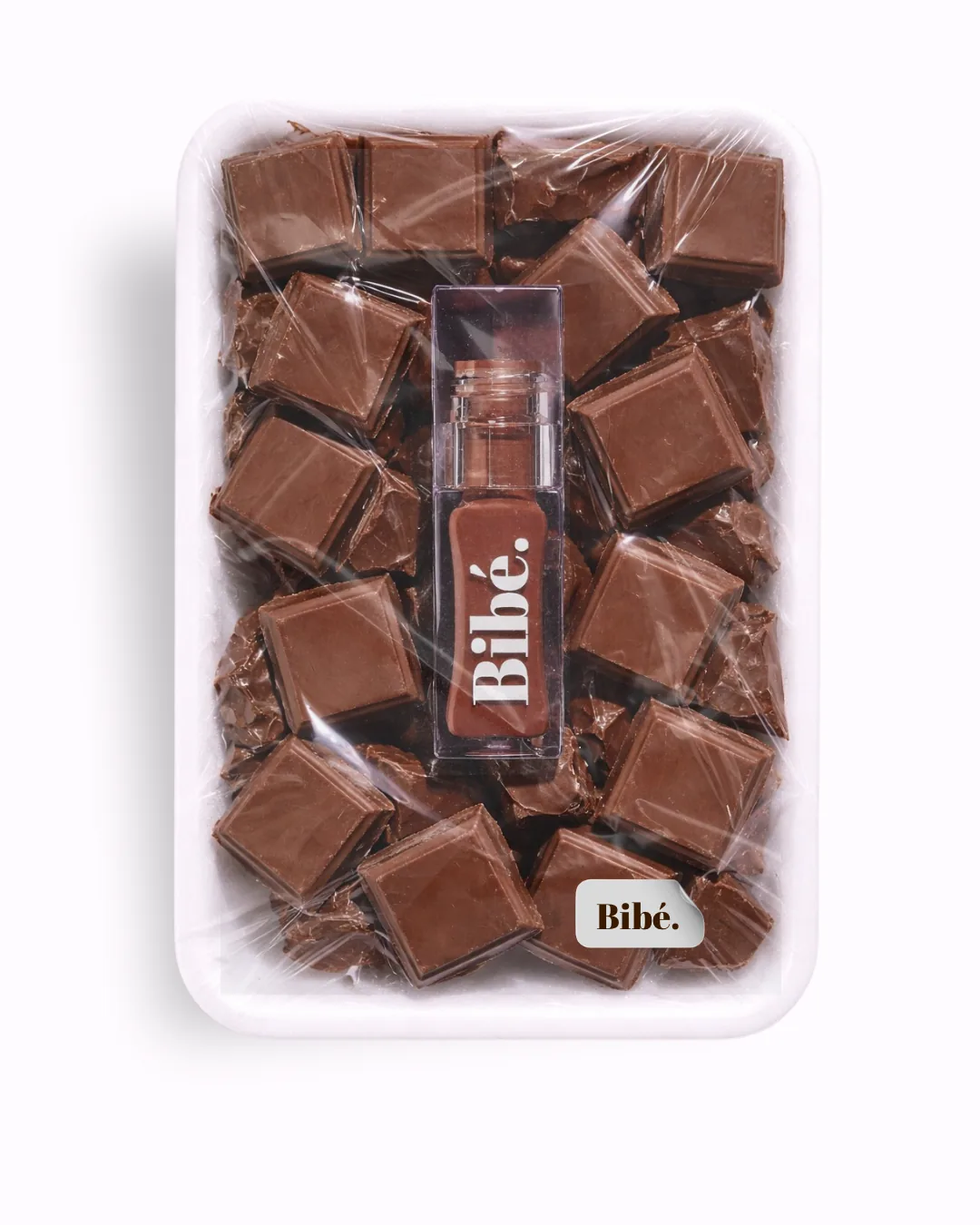 Bibé lip oil styled among chocolate squares