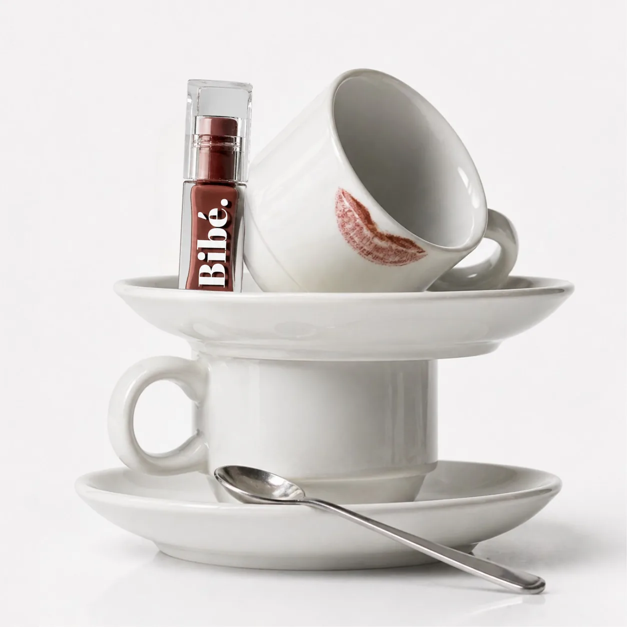 Coffee cup marked with a Bibé lip print, styled still life